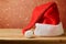 Santa Claus hat on wooden table over bokeh background