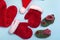 Santa Claus hats, mittens and socks mockup on blue background. Christmas flat mockup, close up top view