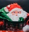 Santa Claus head surrounded of textil decoration like a hut , sock for gifts and inside metal box with christmas decoration