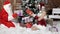 Santa Claus with his granddaughter arranges gifts under the Christmas tree