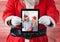 Santa claus holding a digital tablet with photo of christmas couple