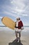 Santa Claus Holding Surfboard On Beach