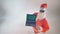 Santa Claus holds a laptop with green screen and appreciates it.