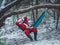 Santa Claus lies in the hammock in the snow-covered winter fores