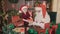 Santa Claus and little assistant packing Christmas gifts for children. CHRISTMAS NEW YEAR CONCEPT