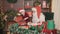 Santa Claus and little assistant packing pine cones for Christmas gifts. CHRISTMAS NEW YEAR CONCEPT