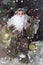 Santa Claus Outdoors Beside Christmas Tree in Snowfall Carrying Gifts to Children