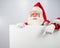 Santa Claus points to an empty white space. Promotional offer for Christmas.