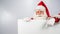 Santa Claus points to an empty white space. Promotional offer for Christmas.