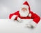 Santa Claus points to an empty white space. Promotional offer for Christmas.