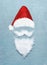 Santa Claus portrait symbol with painted Santa hat and beard with mustache made with snow