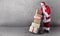 Santa Claus with presents stacked on a delivery trolley with a plain background and copy space