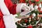 Santa claus reading letters from children in front of christmas