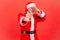 Santa claus in red costume pinching nose with fingers to avoid bad smell and showing stop gesture