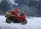 Santa Claus on red motorcycle with a sack driving along winter s