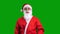 Santa Claus in red suit pointing up on green chroma key background