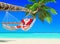 Santa Claus relax in hammock at island palm tropical beach