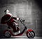 Santa Claus ride motorcycle bicycle scooter with bag full of present gifts with text copy space. New year and Merry Christmas