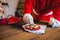 Santa Claus selecting a cookie with glass of milk