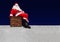 Santa Claus sitting on the chimney at a snowy roof