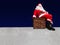 Santa Claus sitting on the chimney at a snowy roof