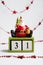 Santa claus sitting on cubes showing the date thirty first on white background with red garland