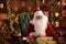 Santa Claus is sitting at his table at home and getting ready to read letters with Christmas wishes