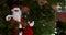 Santa Claus standing near a Christmas tree holding in a red bag gifts for children for Christmas around snow