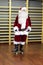 Santa Claus standing on skateboard in fitness studio