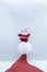 Santa Claus stands above the hat on a white background