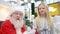 Santa Claus talking and playing surprise games with kids in Shopping Mall. Christmas sales and wishes