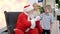 Santa Claus talking and playing surprise games with kids in Shopping Mall. Christmas sales and wishes