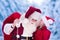 Santa Claus talking to little girl in snowy park