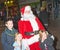 Santa Claus with three smiling children.