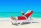 Santa Claus thumbs up gesturing on sunlounger at tropical beach