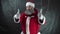 Santa claus thumbs up and ok on dark gray background. Strange middle-aged man with gray beard in Christmas costume likes