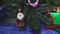 Santa Claus toy or doll is hanging on the Christmas tree next to the gifts