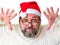 Santa Claus is trying to scare. Strange Santa Claus. A middle-aged man with a gray beard and glasses looks like Santa Claus. Santa