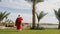 Santa claus walking near a resort on the seaside near palm trees