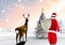 Santa claus walking on snowy landscape with reindeer