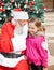 Santa Claus Whispering In Girl\'s Ear Against