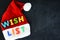 Santa Claus wish list concept with colorful text on Santaâ€™s red hat
