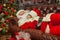 Santa Clause snoozing in a decorated living room with sack full