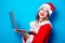 Santa Clous girl in red clothes with laptop computer