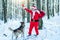 Santa with dog. Delivery christmas gifts. Santa Claus comes with gifts from the outside.
