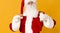Santa eating cookie and drinking milk on orange background