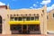 Santa Fe street with shop with corbels and bright yellow awning under pretty blue sky with clouds