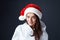 Santa Girl. Beautiful Woman In Christmas Hat Portrait. Model Biting Lips And Looking At Camera.