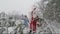 Santa and granddaughter happily waving their hands in the snow-covered forest. Slow motion