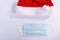 Santa hat with a protective mask on a white background, top view. christmas coronavirus concept